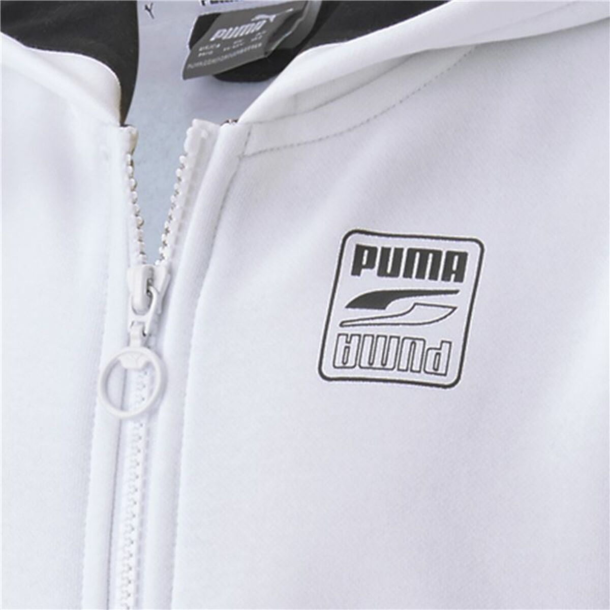 "Detaljbild på Puma-logotyp på Rebel Block Full-Zip Hoodie vit sportjacka barn."