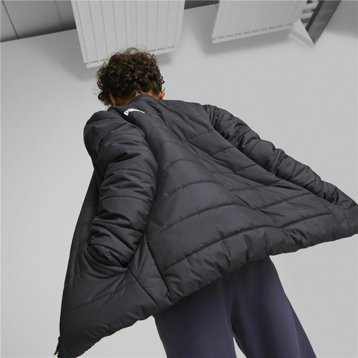 "Puma sportjacka för pojkar i svart med ståkrage och logotyp på bröstet."