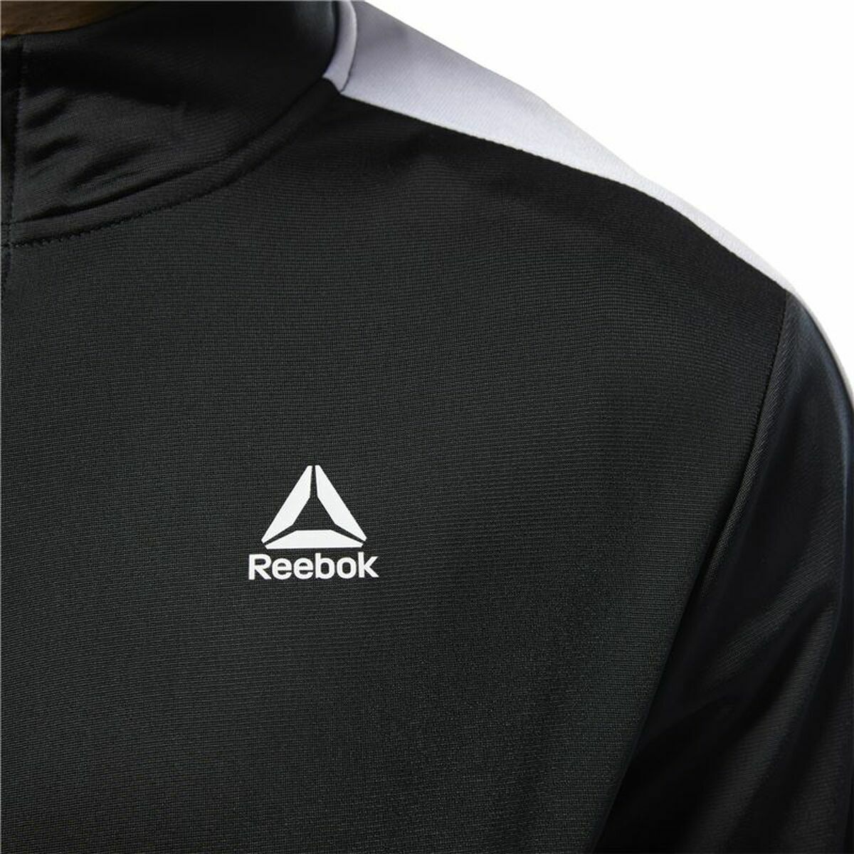 "Detaljbild av Reebok-loggan på Essentials Linear Logo träningsjacka herr svart."
